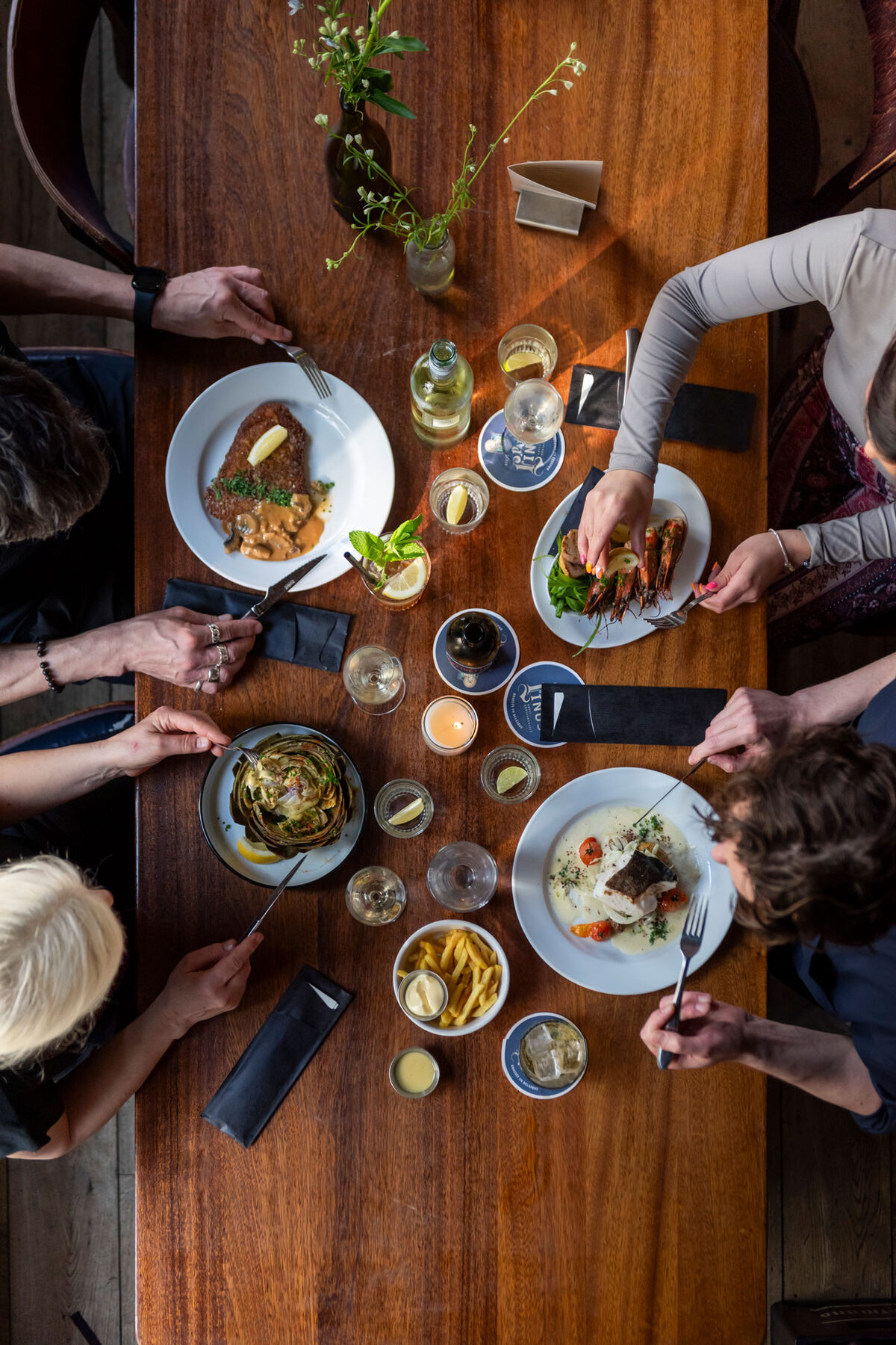 Vrienden delen gerechten aan een houten tafel