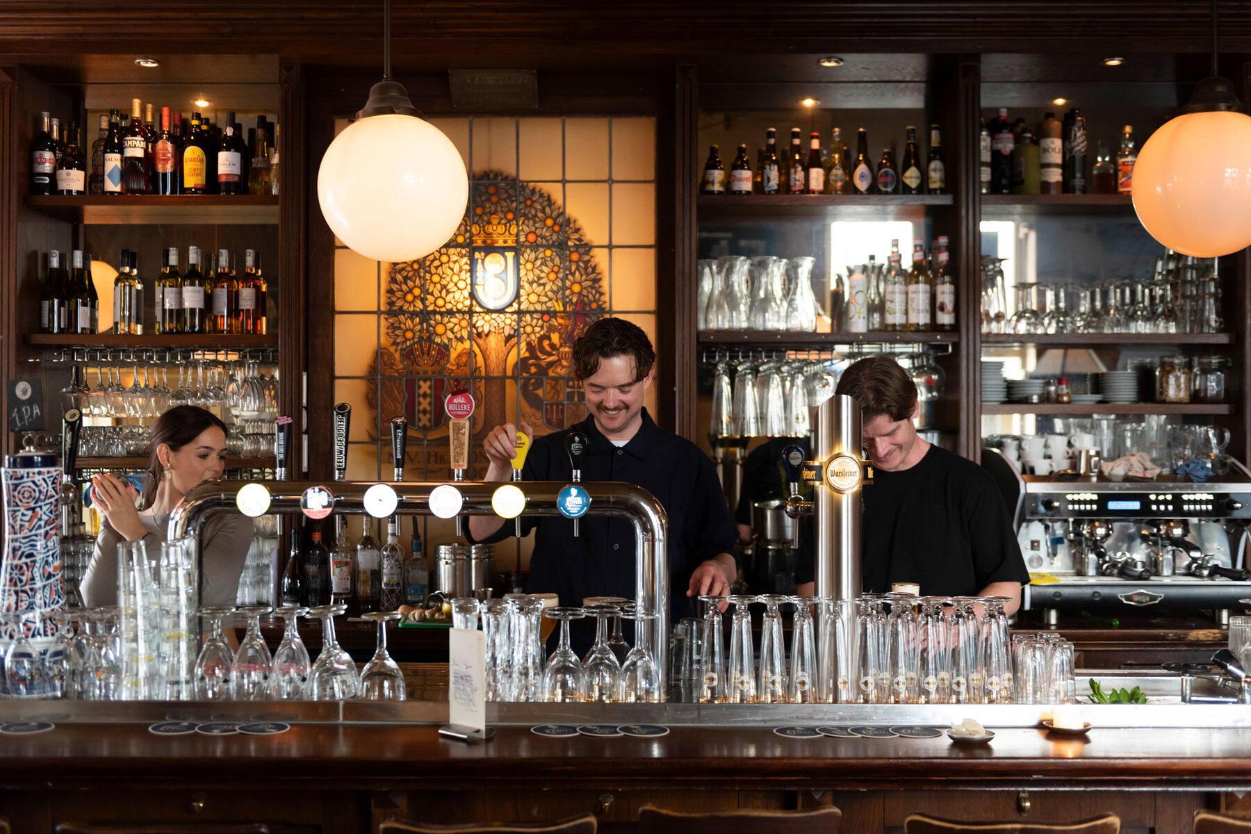 Bartenders achter de tap in het bruine café