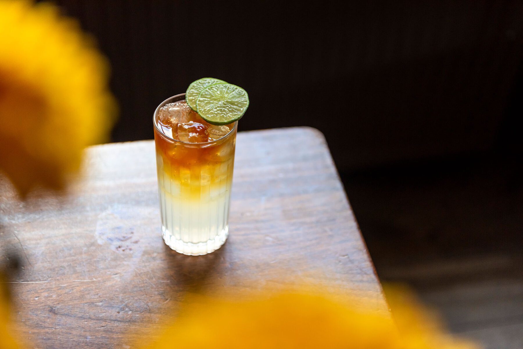 Dark 'n' Stormy-cocktail met limoen op een houten tafel