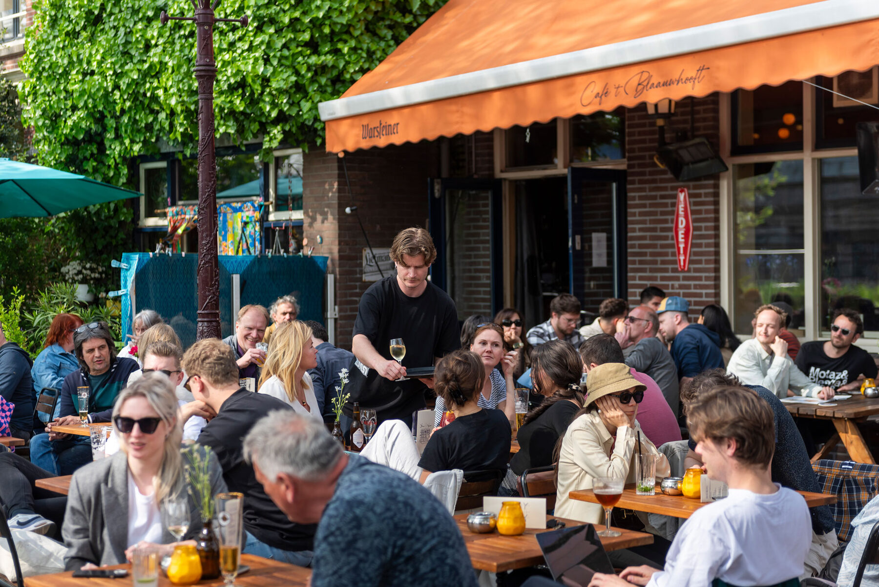 Vol terras in de zon met oranje luifel